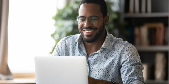 Empresário sorridente utilizando um certificado digital no laptop