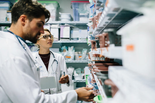 Dois médicos em jalecos inspecionando produtos farmacêuticos em prateleiras