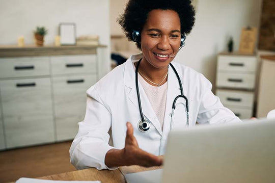 Profissional médica trabalhando em seu consultório com seu notebook