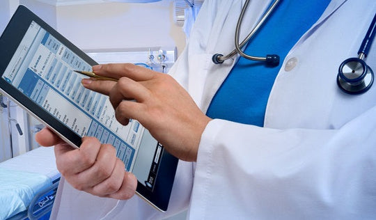 Médico utilizando um tablet para revisar as informações do paciente e prestar cuidados, auxiliando no atendimento e na documentação médica